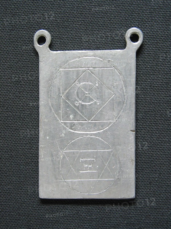 Lead amulet engraved with esoteric signs.