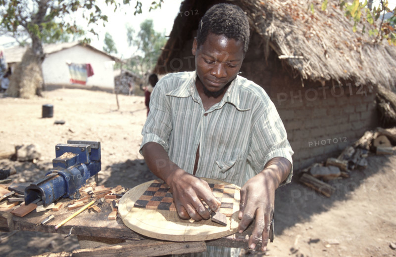 Man making a wooden chess board
\n