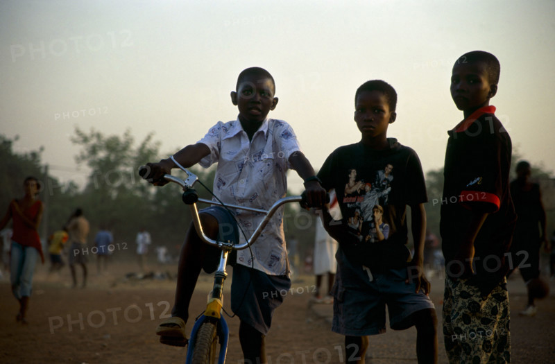 In the suburb of Corofina Nord, Bamako, Mali, young people gather in the late afternoon at a large dusty field to play sport - basketball and soccer - socialise, and play. The field seems to be the centre of social life in the area. 

Young boys come out to play on bikes or with a soccer ball