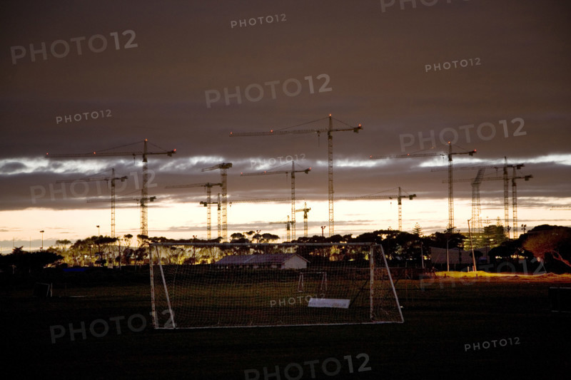 Seen from soccer fields in Greenpoint, construction cranes rise above the site of the new Greenpoint Stadium in Greenpoint, Cape Town. The all-weather stadium is designed to seat 70,000 people. The Stadium is one of 10 that will be used in the 2010 FIFA World Cup‚Ñ¢ / 2010 Soccer World Cup