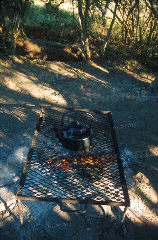 heating water in a kettle over a fire