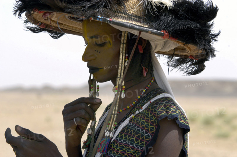 Wodaabe men examine their appearance in handmirrors at a festival in InGall, near Agadez in Niger on Friday Sept. 26, 2003. The Wodaabe, a nomadic West African tribe, value male beauty and are taught from an early age to look into mirrors to consider their appearance. The Wodaabe men perform a dance, showing off the whiteness of their teeth and eyes, to compete for honour and selection as the most beautiful man by women of the tribe at a festival celebrated at the end of the rainy season.  (Photo/Christine Nesbitt)