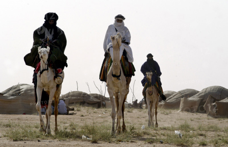 Nomads are seen on camels at the Salt Cure festival drawing nomads from all over the region to InGall, near Agadez in Niger on Thursday Sept. 25, 2003.  The Wodaabe men perform a dance, showing off the whiteness of their teeth and eyes, to compete for honour and selection as the most beautiful man by women of the tribe at the festival celebrated at the end of the rainy season. (Photo/Christine Nesbitt)