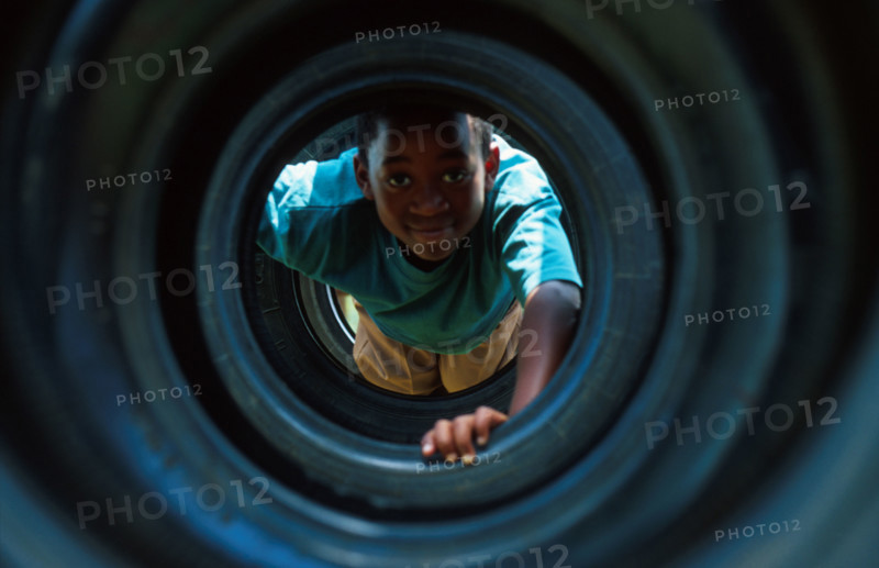 boy playing in a tyre