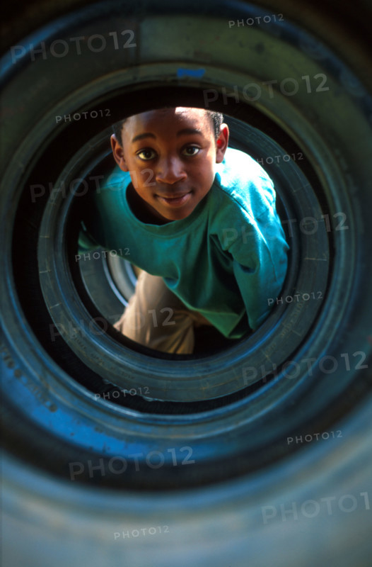 boy playing in a tyre