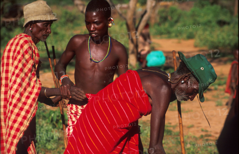 Kirana Lerimara, a young Samburu man takes the hand of one of his tribal elders