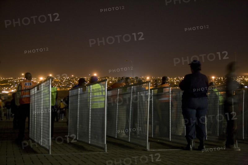 Une policière observent les procédures à l'entrée d'une des portes du Stade Orlando, Afrique du Sud