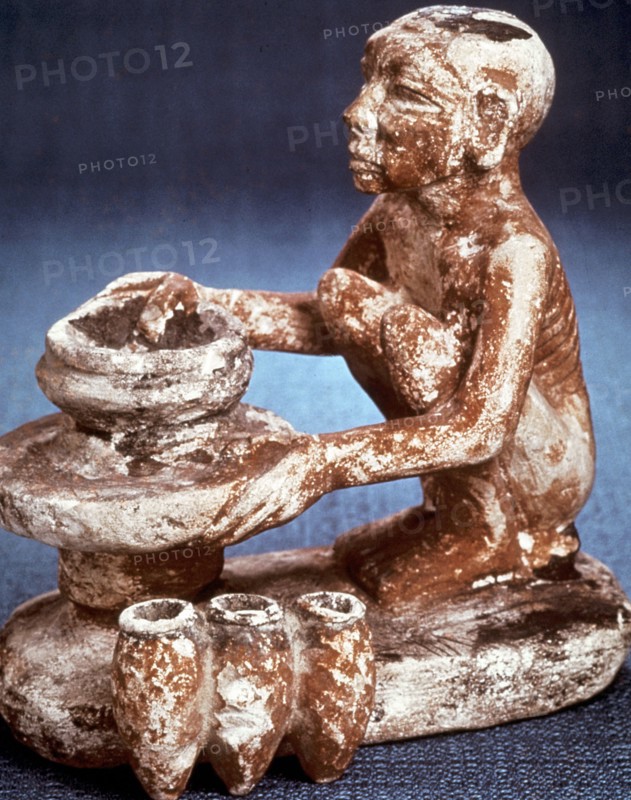 Potter turning vessels on a wheel:  Limestone model
