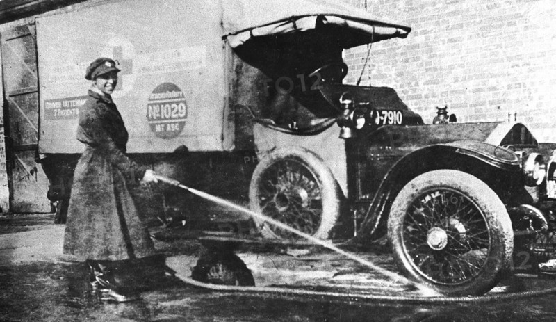 Volunteer English woman driver washing down her ambulance