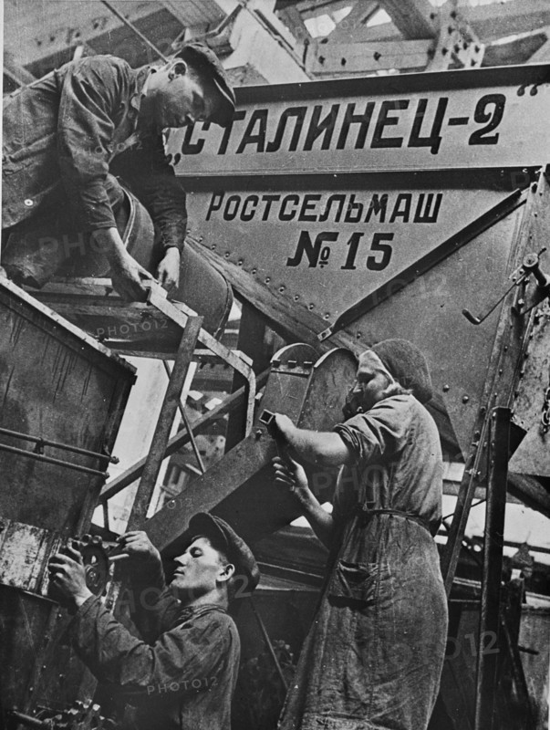 Men and women workers at a combine harvester factory