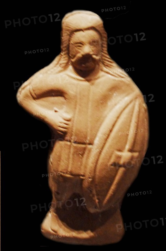 A statuette of a barbarian soldier carrying a Celtic shield