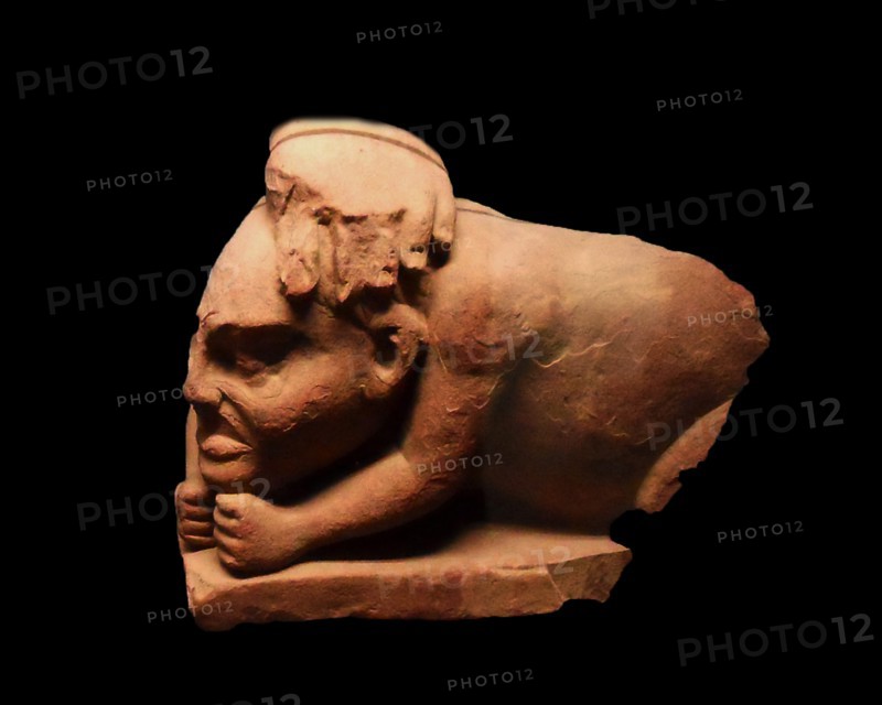 Crouched sandstone figure of a Yaksha