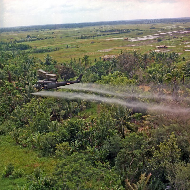 A UH-1D helicopter from the 336th Aviation Company sprays a defoliation agent on a dense jungle area in the Mekong Delta