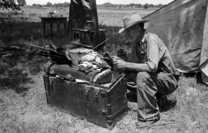 Veteran migrant agricultural worker examining contents of his trunk, Oklahoma