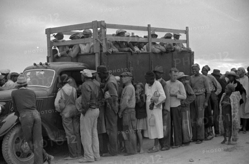 Vegetable workers, migrants, waiting after work to be paid.