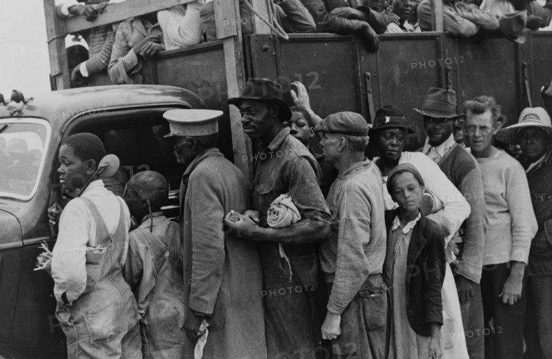 Vegetable workers, migrants, waiting after work to be paid. Near Homestead, Florida. dated 19380101