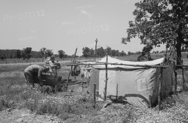 Camp of migratory workers who move along the road pushing their belongings in a cart, camped near Vian, Sequoya County, Oklahoma 19390101.