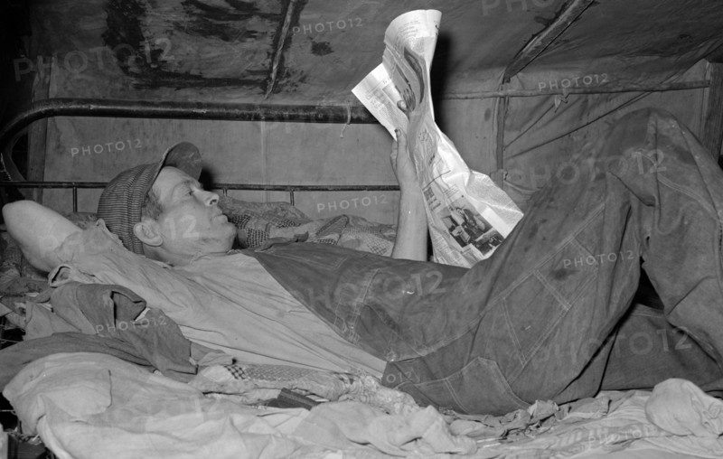 Migrant worker on bed in tent home. Mercedes, Texas. 19390101