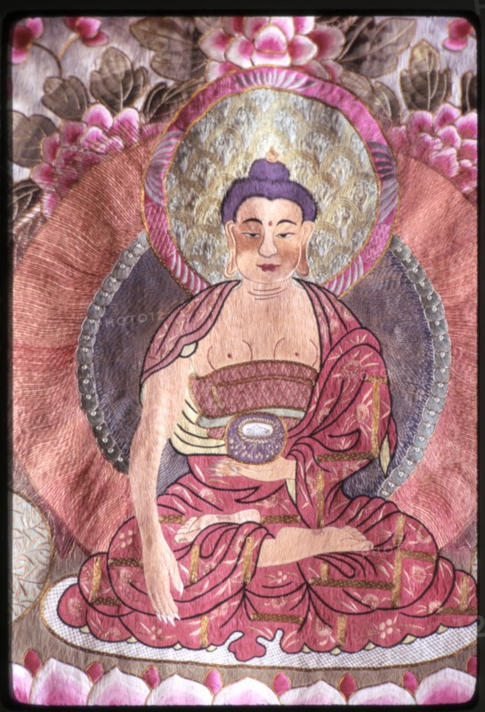 Photograph of a religious silk textile (thangka) depicting Buddha