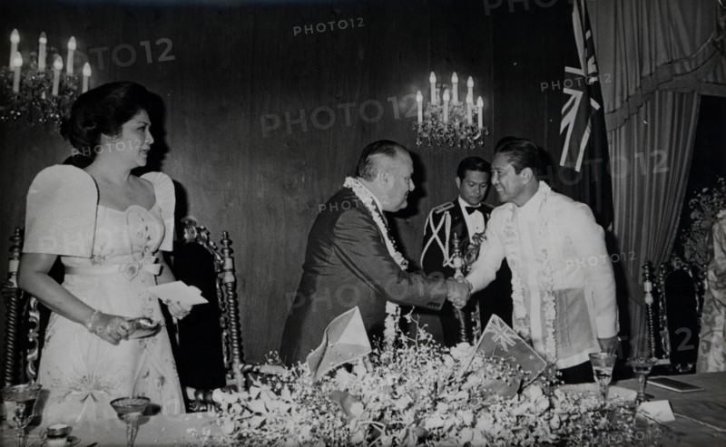 President Ferdinand Marcos greets New Zealand leader Robert Muldoon as the First Lady Imelda Marcos watches.