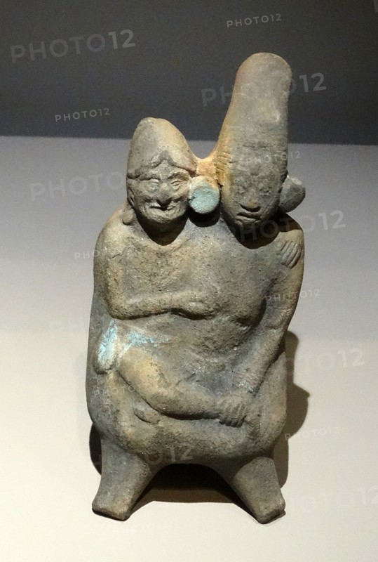 Mayan ceramic figurine of a young woman in the embrace of an old man.