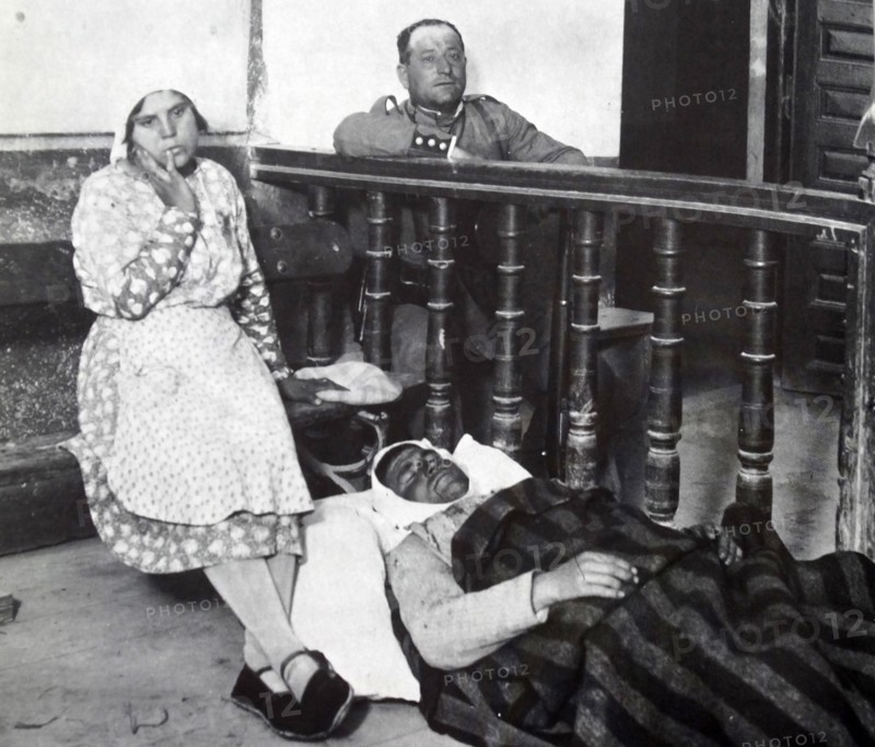 A wounded peasant farmer lies injured and under guard during peasant riots in Spain 1930