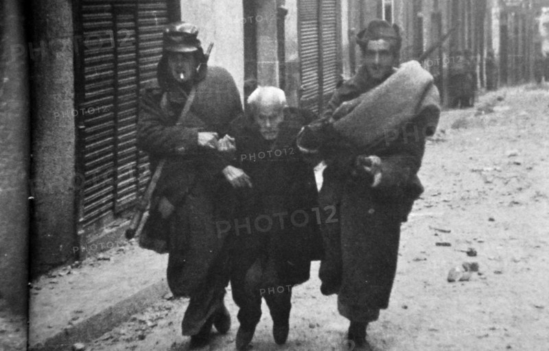 A civilian is helped to safety at Teruel, during the Spanish Civil War.