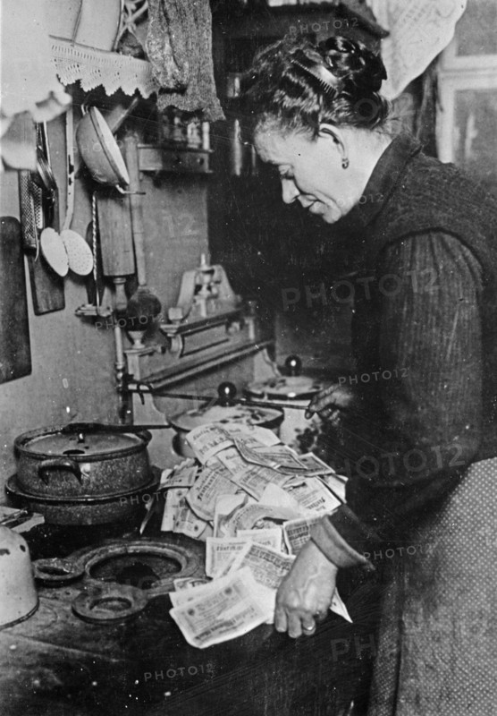 German woman starting a fire with a pile of marks
