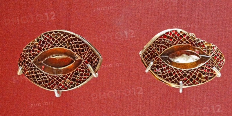 Anglo Saxon metalwork; 5th-6th Century AD. Pair of eye-shaped mounts, with cloisonné garnets