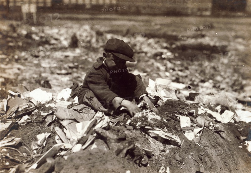 Photograph of a young scavenger going through the Trash on Pleasant Street dump