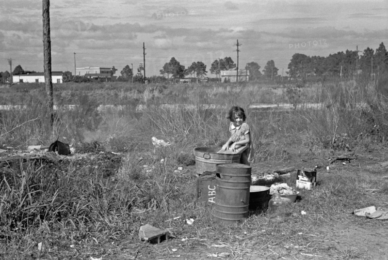 Arthur Rothstein, photograph: Wash day. The daughter of a migrant fruit worker from Tennessee, now encamped near Winter Haven, Florida, 1937