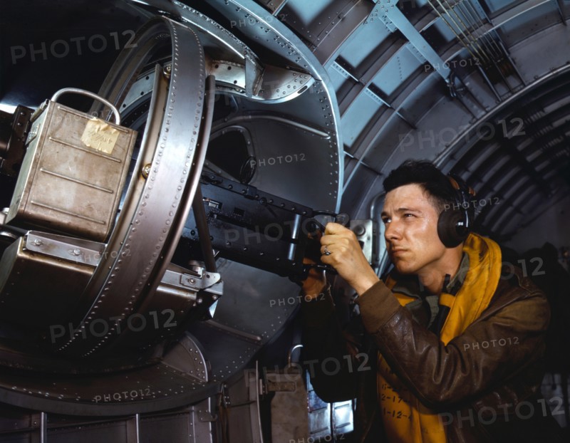 American airman using a a side machine gun of a B-17 Flying Fortress bomber