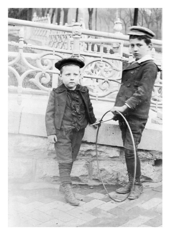 Two boys playing with circular hoops c1900