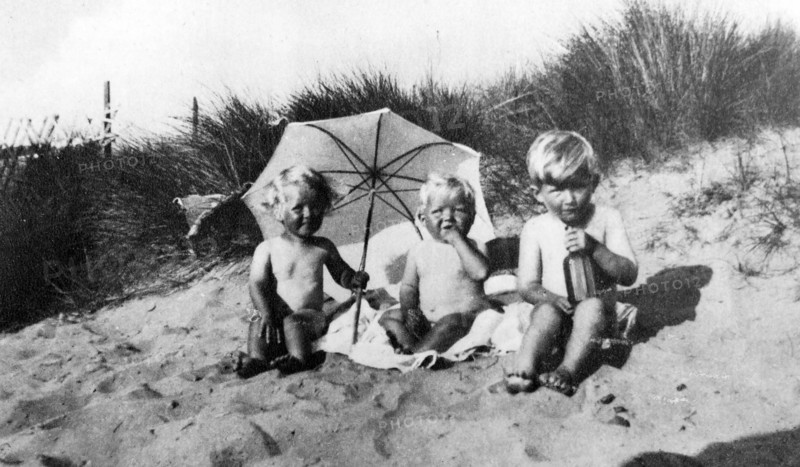 Vintage photograph of three children on a sandy shore 1930