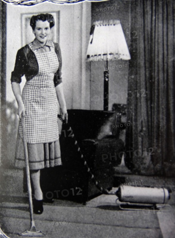 Photograph of a housewife using a hoover