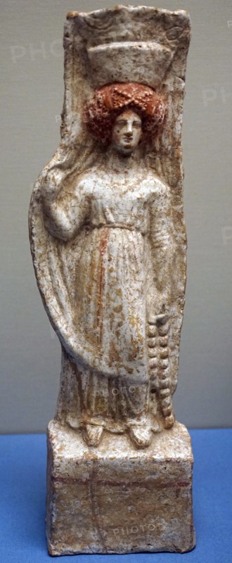 Terracotta figure of a woman wearing a chiton and Polos crown