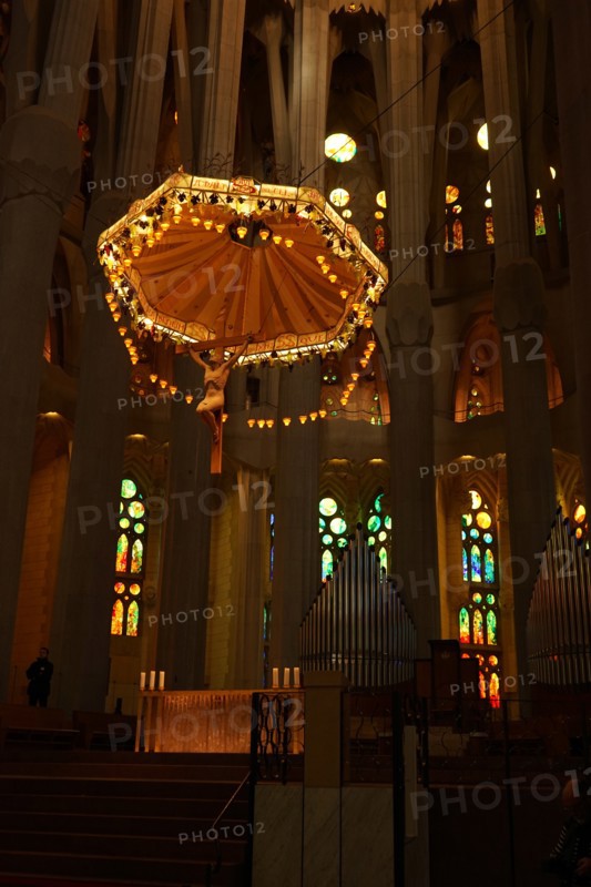 View of the suspended crucifix and glass altar within the Basílica i Temple Expiatori de la Sagrada Família