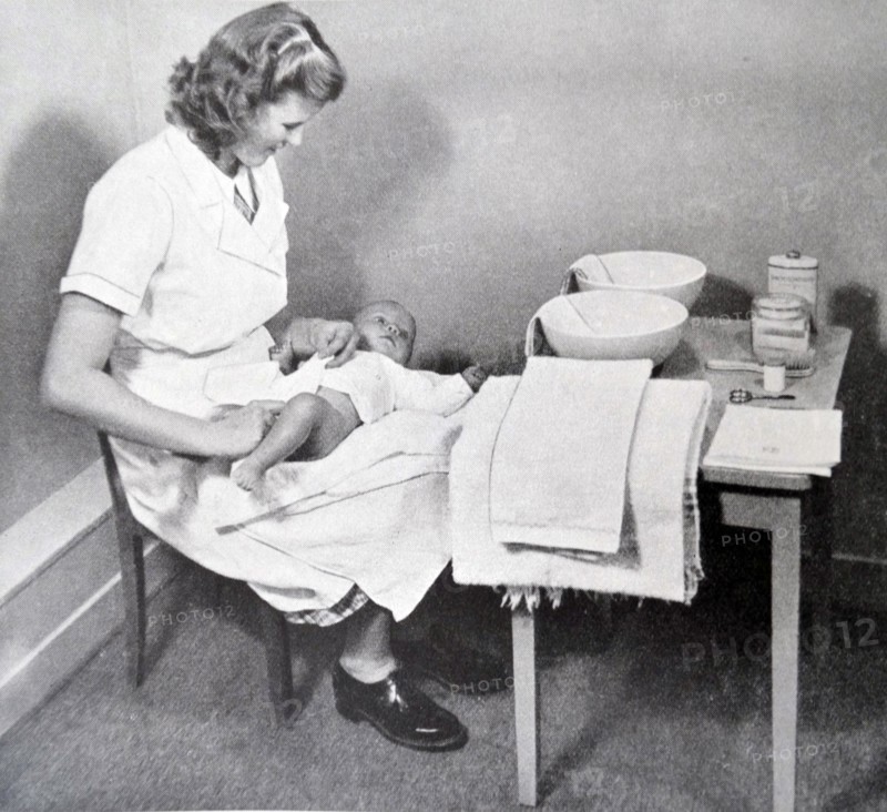 a nurse changing and cleaning a new-born baby