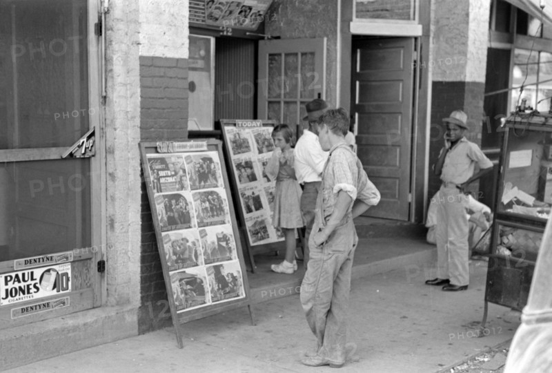 Children looking at posters in front of movie, Saturday, Steele, Missouri 1938