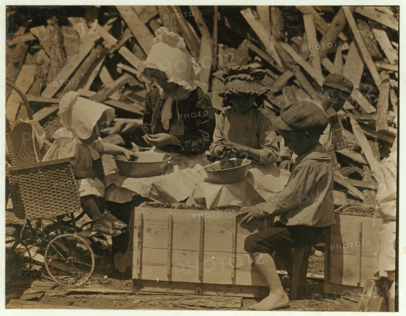 Mother and children hulling strawberries
