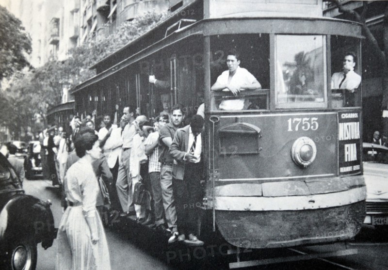 Busy street scene in Rio de Janeiro, Brazil as people crowd a tram