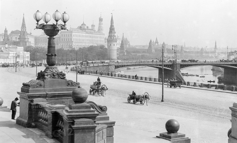Photograph of horse-drawn wagons and motor trucks