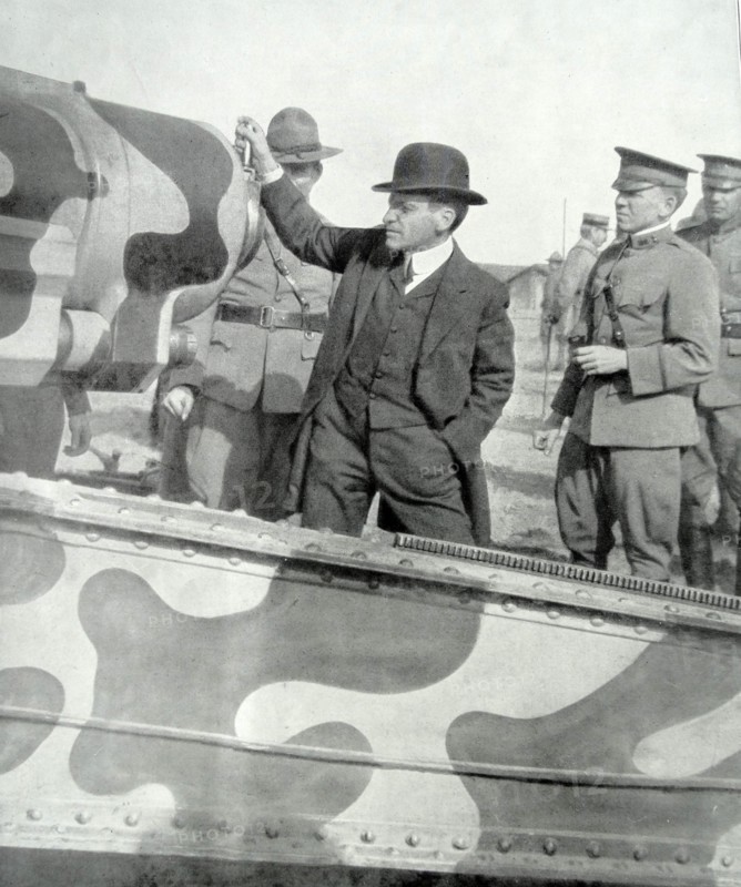 US Secretary of war visits a camouflaged artillery gun in France in WWI.