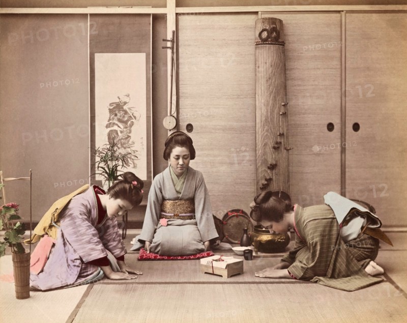 Colour Photograph of two Japanese women greeting another woman with a gift box tied with mizuhiki