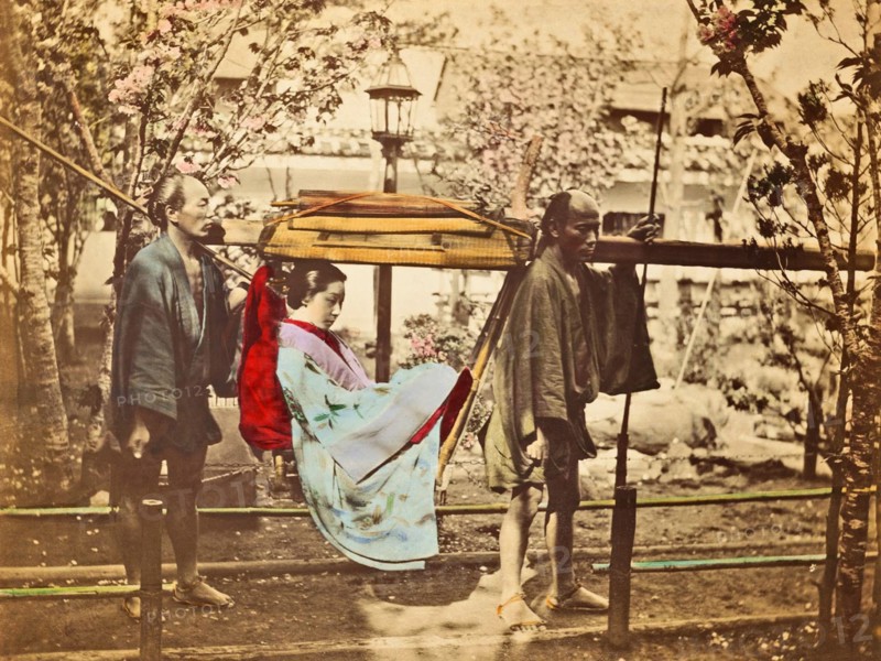 Colour photograph of a Japanese women in basket palanquin