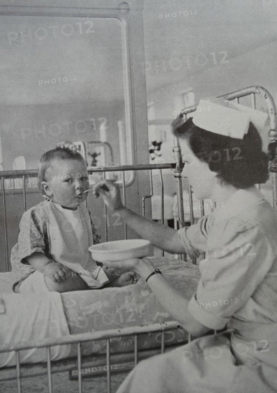 Feeding a baby is one of the many varied duties of the nurse, whose tasks call for skill and patience.
