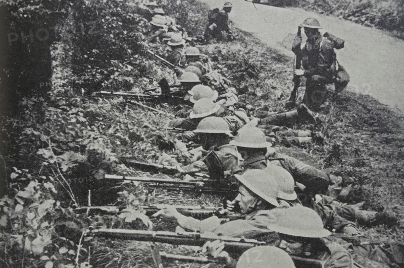 Photograph of Soldiers taking up position by the roadside