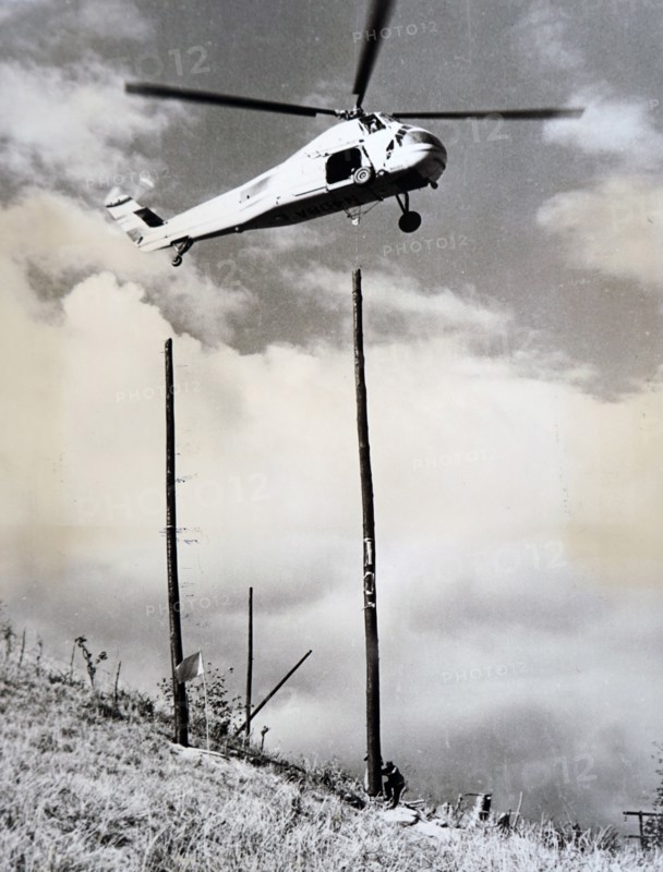 Photograph of a helicopter being used to aid the construction of a building