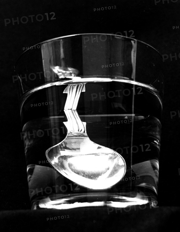Photograph demonstrating total internal reflection: In a tumbler of water, the reflected handle of the spoon can be seen in the surface of the water above the spoon itself