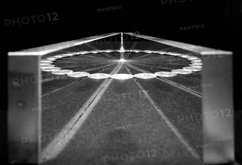 Photograph of coins in a series of reflective mirrors giving the effect of a circle